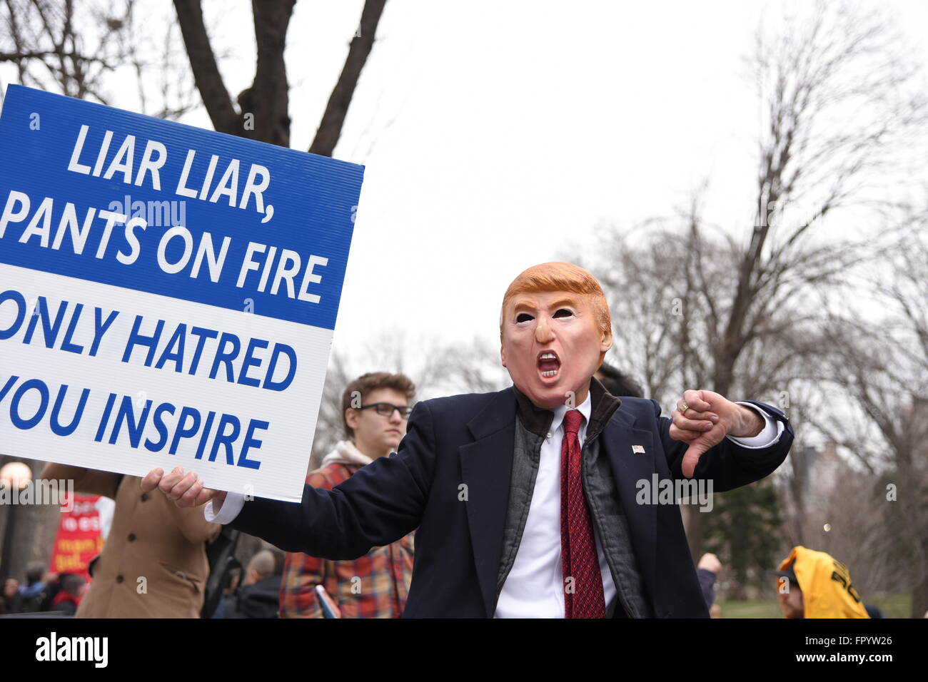 New York City, United States. 19th Mar, 2016. Activist in Donald Trump mask with long nose chants. An estimated one thousand activists gathered to rally at Columbus Circle to oppose the candidacy of Republican front-runner Donald Trump, later marching to Trump Tower during which NYPD officers made several arrests. © Andy Katz/Pacific Press/Alamy Live News Stock Photo