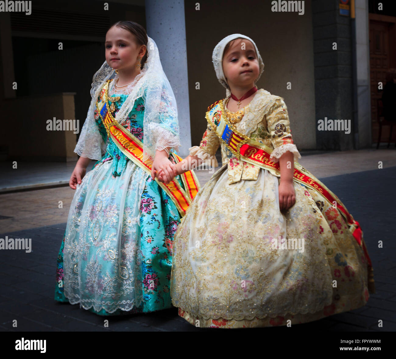 Two cute young girls in traditional Spanish Costume taking part in the Fallas Procession in Gandia Spain Stock Photo