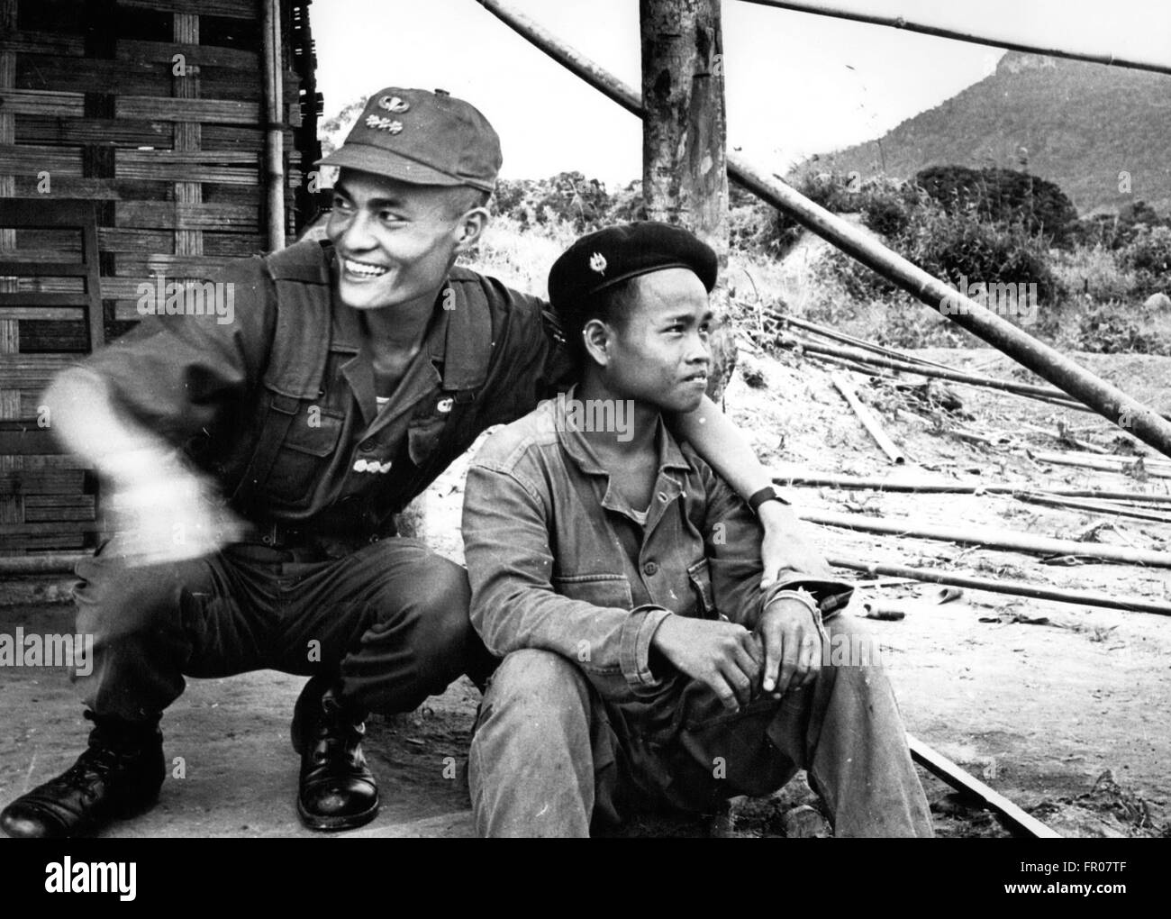 1962 - Laos. Speculation persists in Saigon that South Vietnamese government troops will form an alliance wit right-wing Lao troops and across the mountainous jungles in Laos. These photo show a South Vietnamese captain (in dark fatigues and baseball-like cap) and South Vietnamese civic action girls with Lao troops (in maroon berets) © Keystone Pictures USA/ZUMAPRESS.com/Alamy Live News Stock Photo