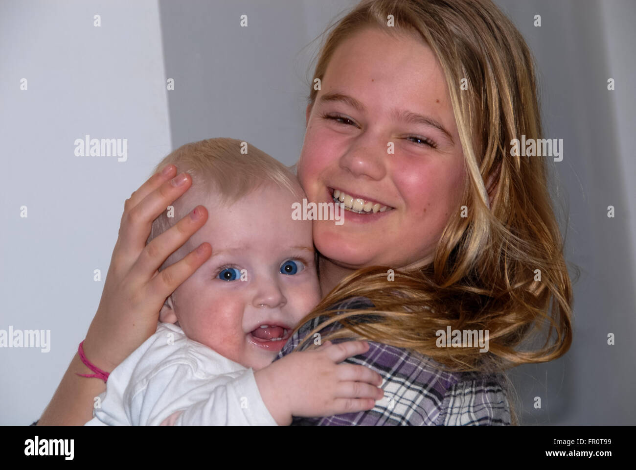 girl holds little boy in arms and laughs Stock Photo - Alamy