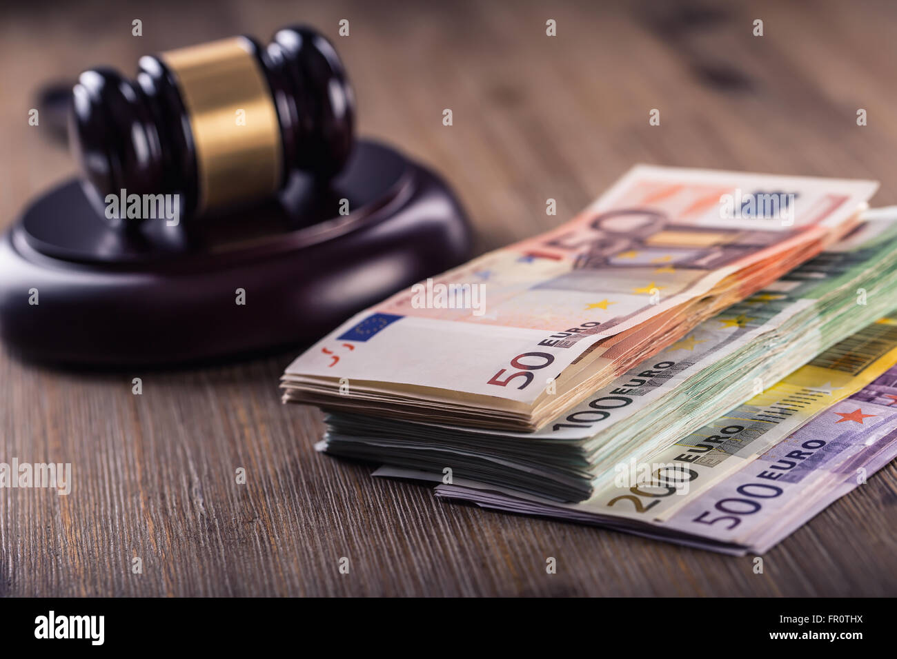 Judge's hammer gavel. Justice and euro money. Euro currency. Court gavel and rolled Euro banknotes. Representation of corruption Stock Photo