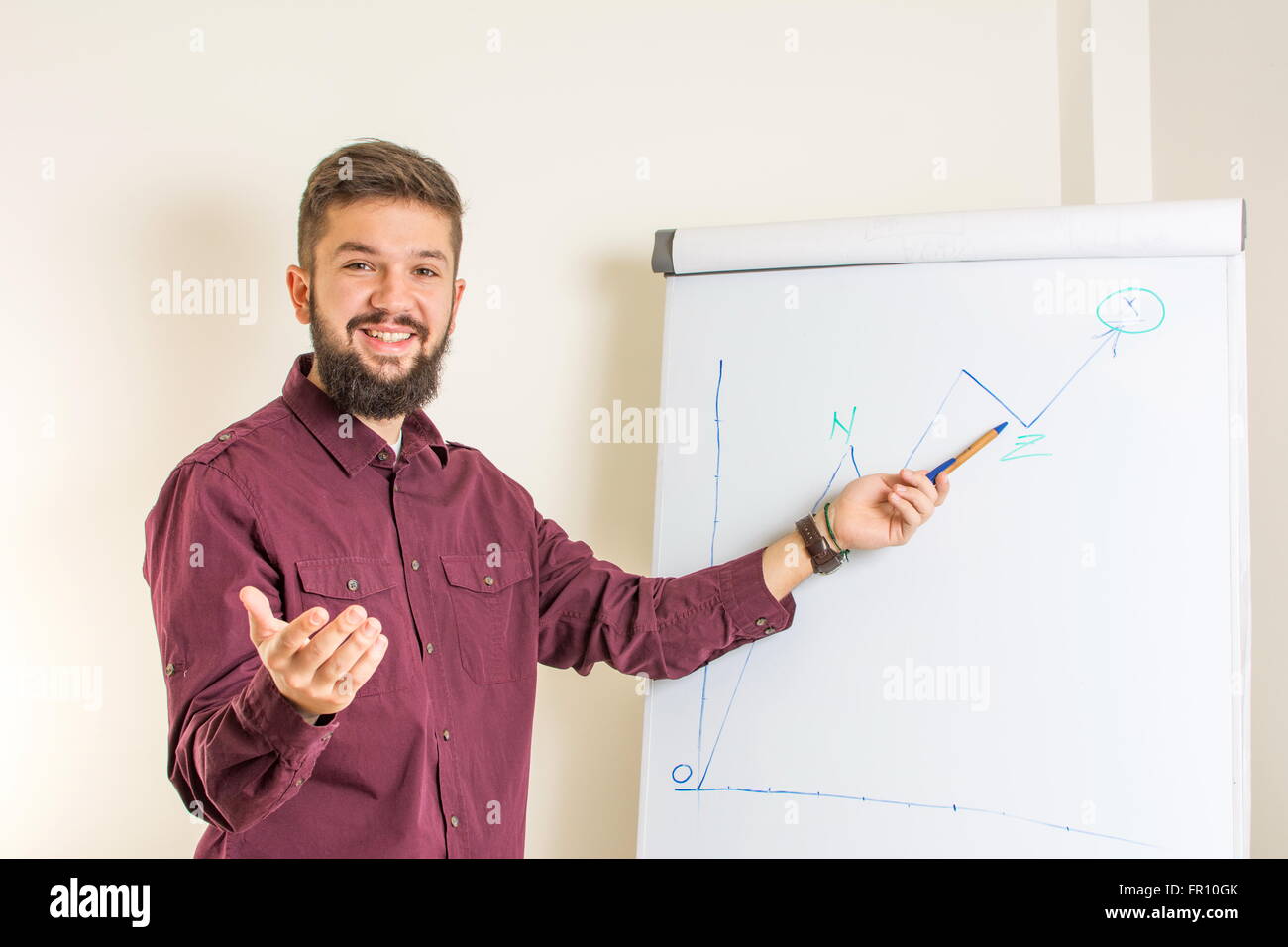 Young bearded man presenting by the flipchart Stock Photo