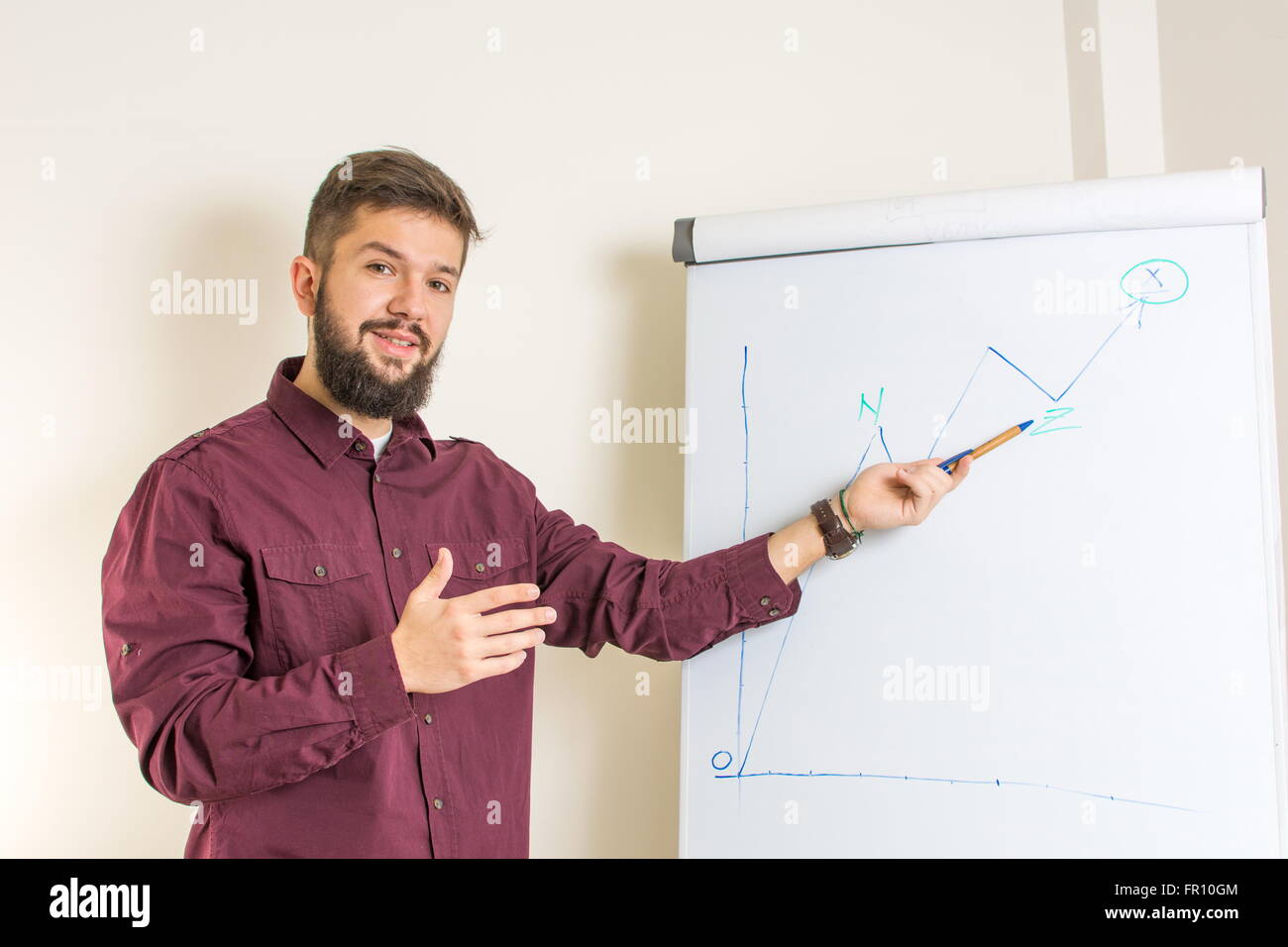 Young bearded man presenting by the flipchart Stock Photo