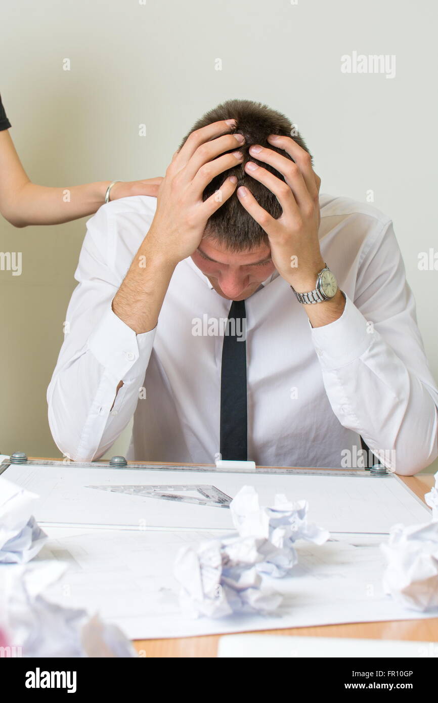 Supporting a businessman under stress at work Stock Photo