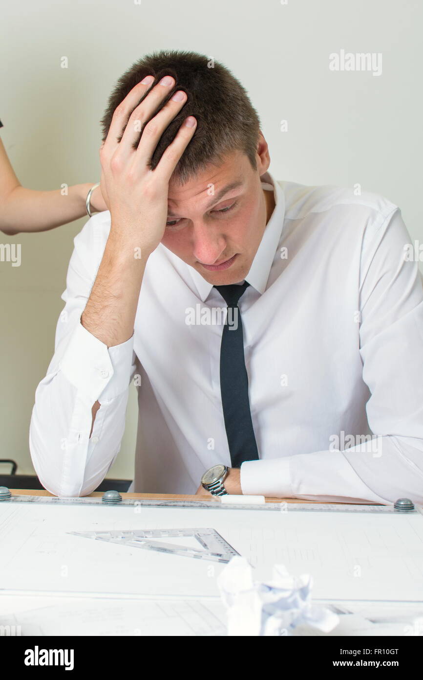 Consoling a young moody businessman at work Stock Photo