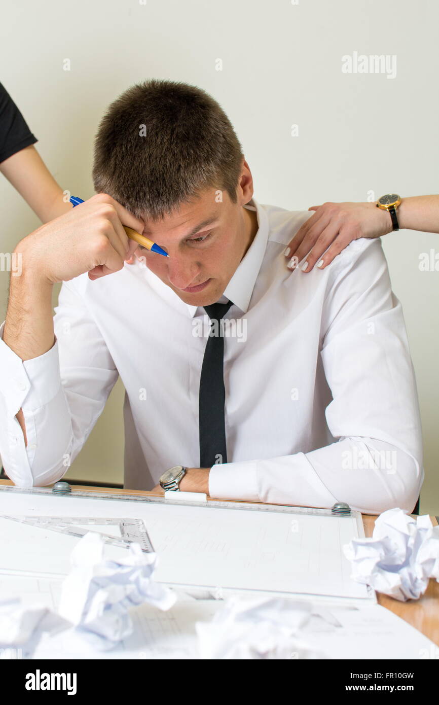 Consoling a young moody businessman at work Stock Photo