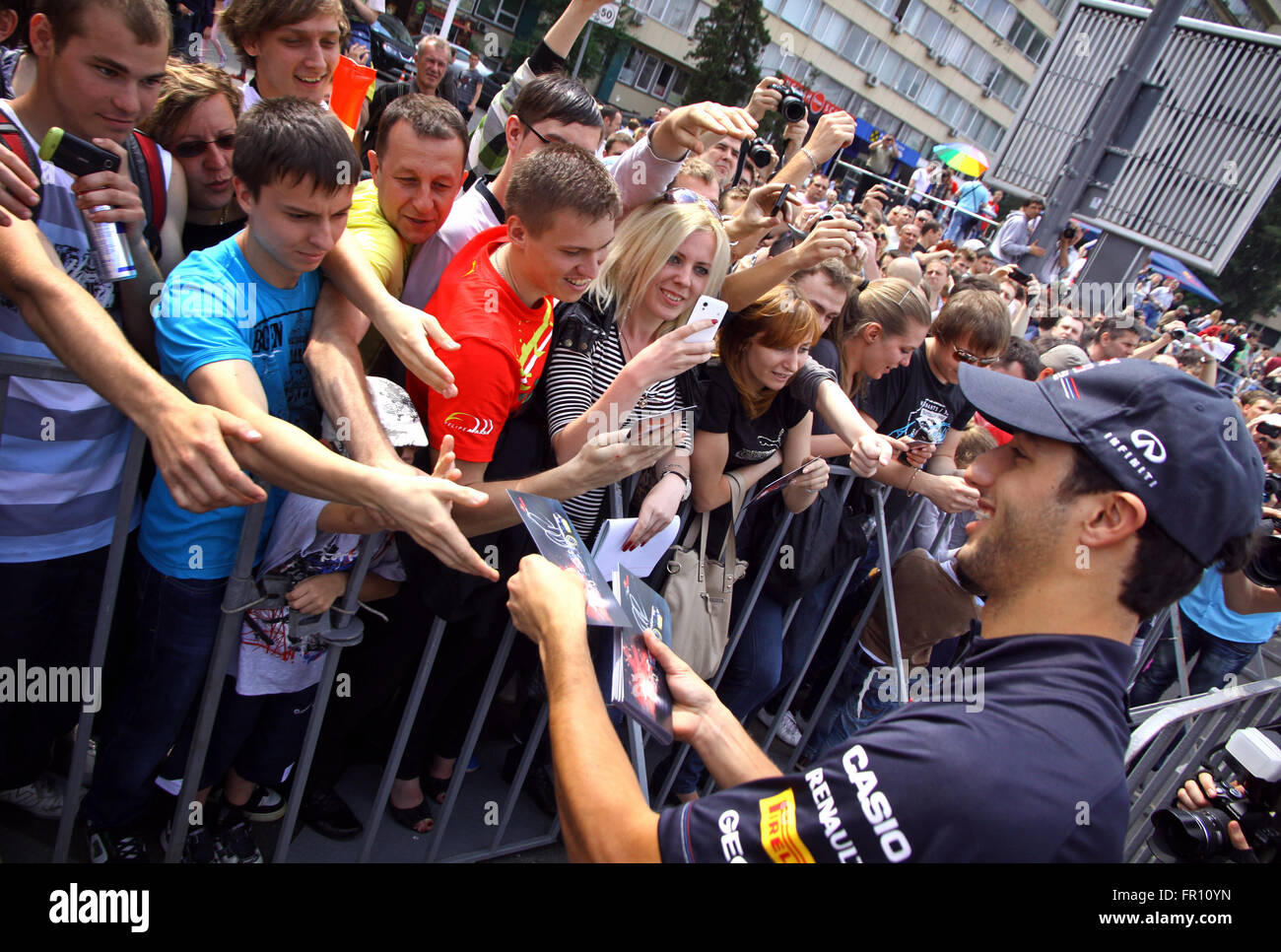 KYIV, UKRAINE - MAY 19, 2012: Formula 1 driver Daniel Ricciardo of Red Bull Racing Team signs autographs during Red Bull Champions Parade on the streets of Kyiv city Stock Photo