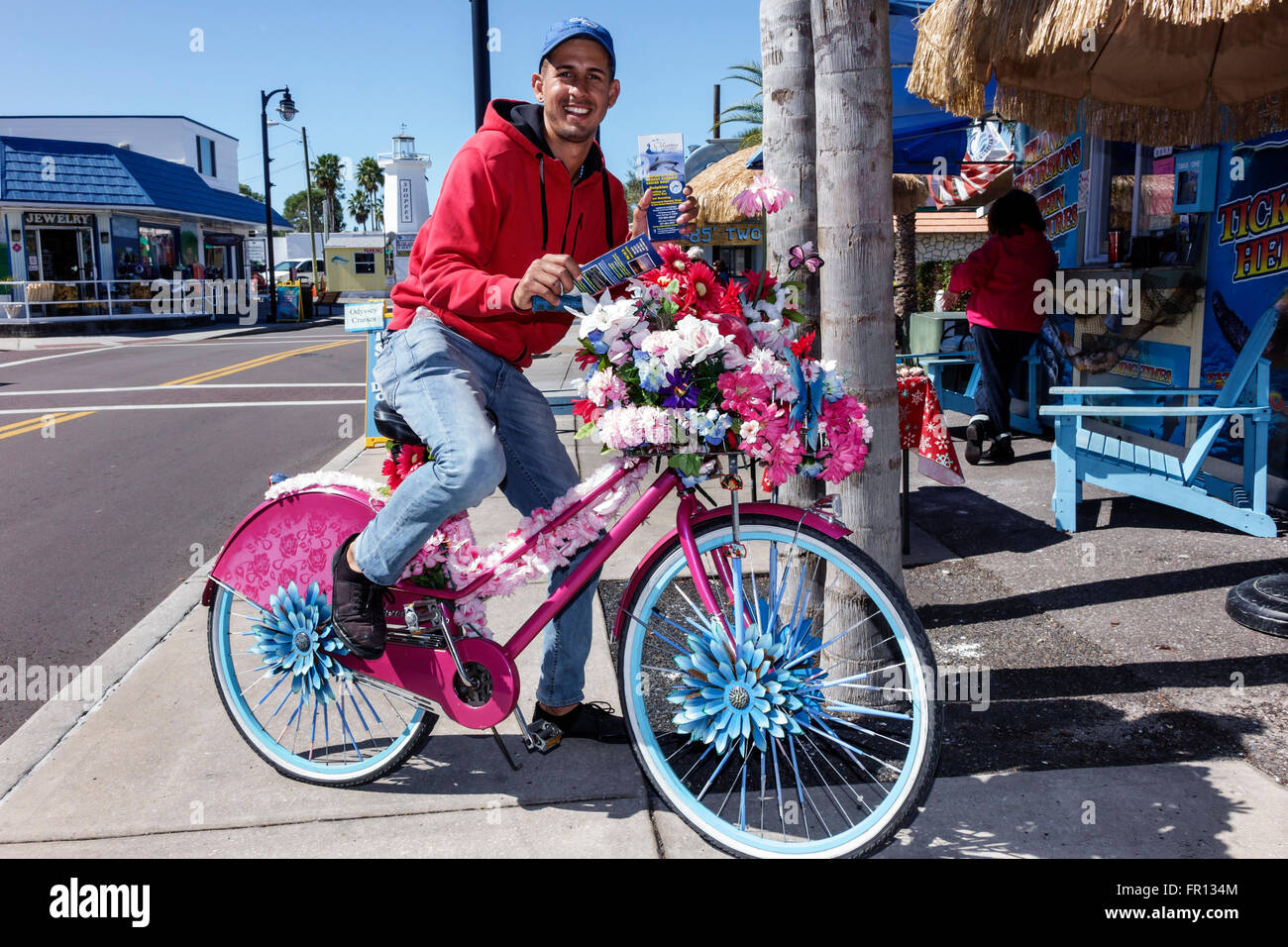 Florida Tarpon Springs,Dodecanese Boulevard,pink bicycle,bike,flowers,Hispanic adult,adults,man men male,handing out brochures,FL160212008 Stock Photo
