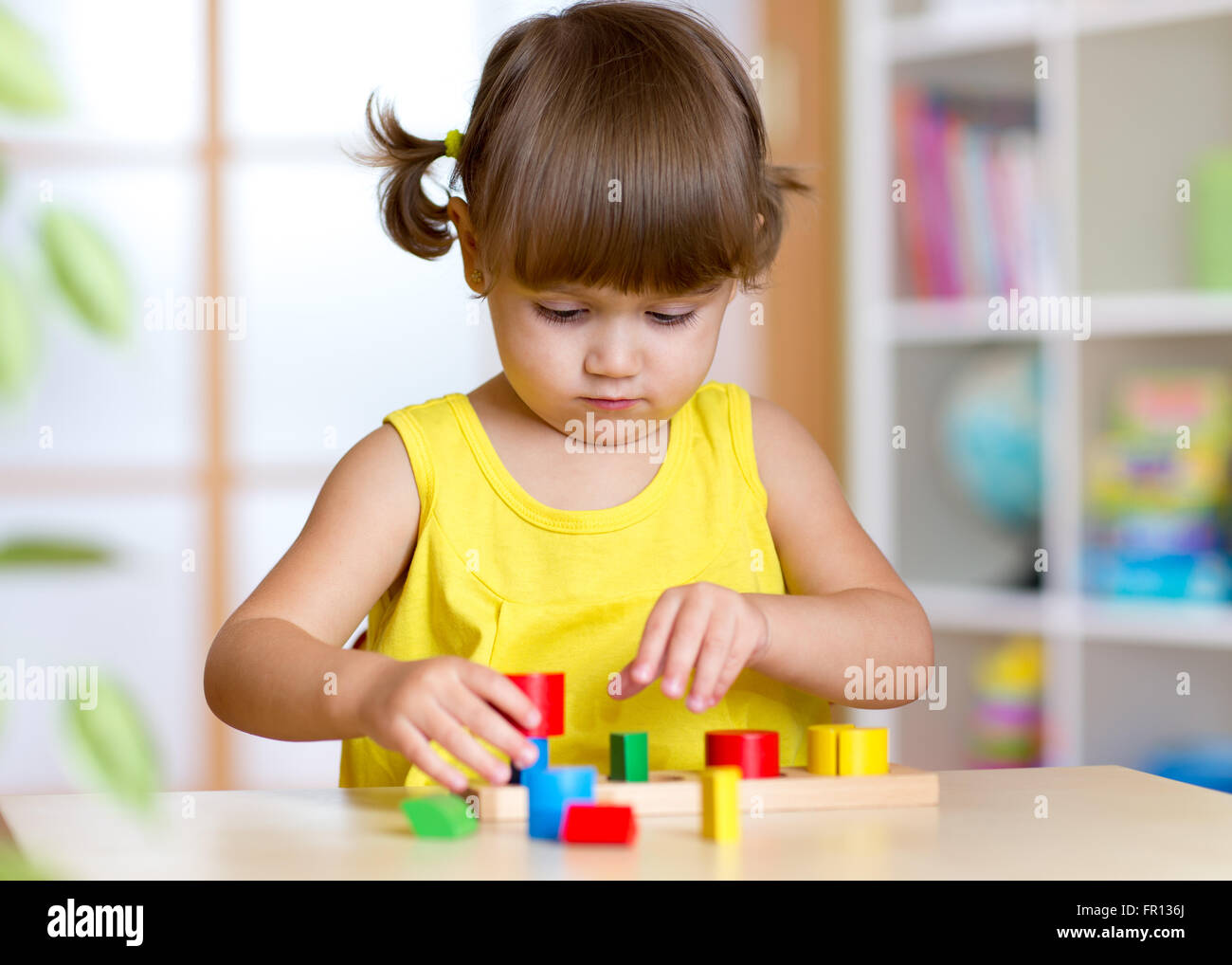 Child girl kid playing with sorter toys Stock Photo - Alamy