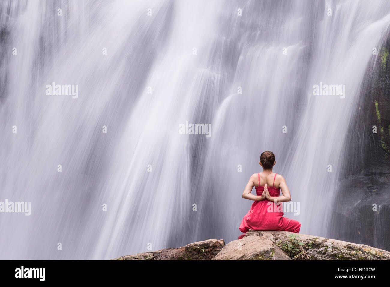 Female doing yoga outdoor at beautiful waterfall. Exercise for Health ...
