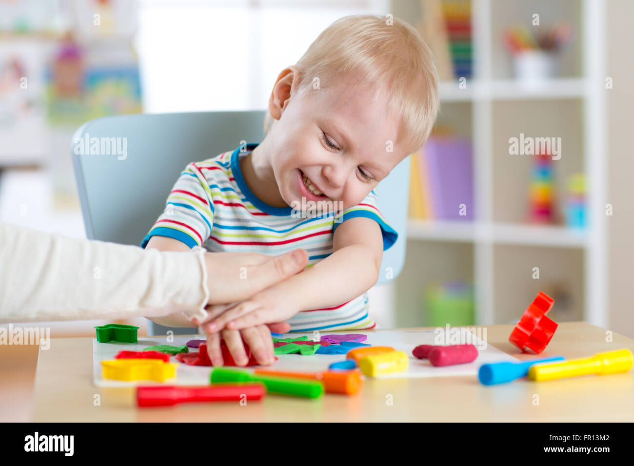 Child boy plays with clay dough, education and daycare concept Stock
