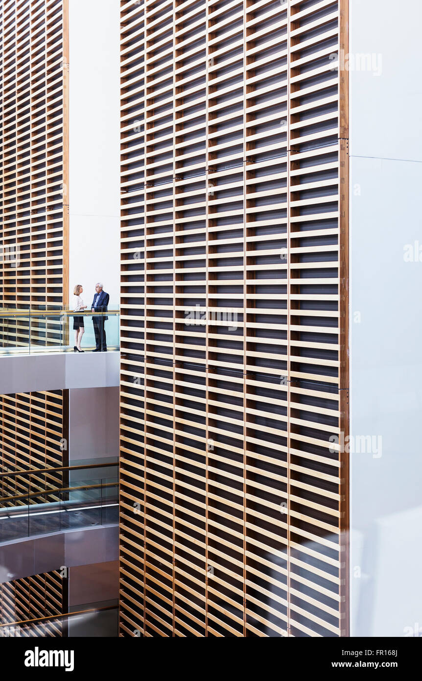 Business people talking on walkway in modern office atrium Stock Photo