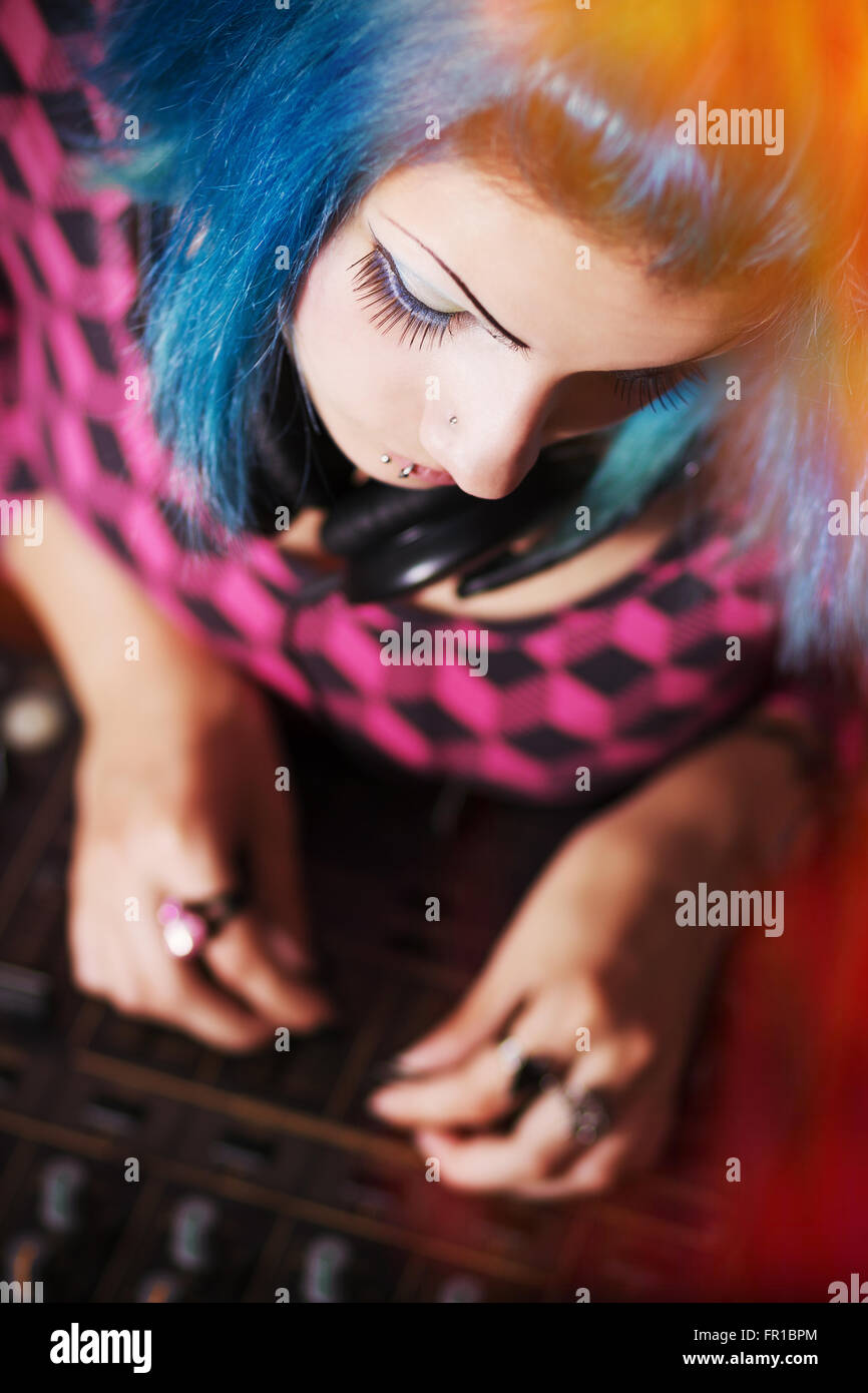 Hip young girl DJ mixing music on a professional sound mixer Stock