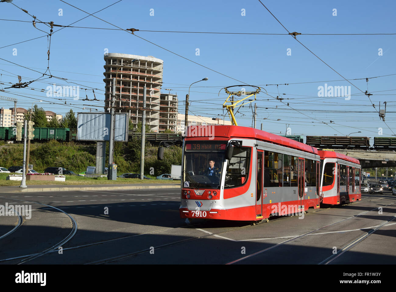 Two-car double-sided tram of service 39 leaving mixed traffic segment to segregation of Novocherkassky prospect Stock Photo