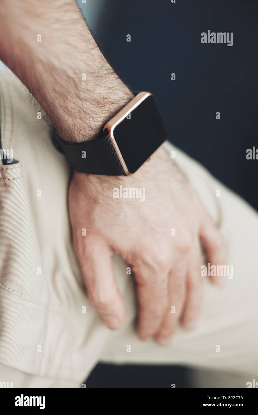 Male hand with trendy smart watch in focus. Elegant and stylish modern technology. Model unrecognizable. Stock Photo