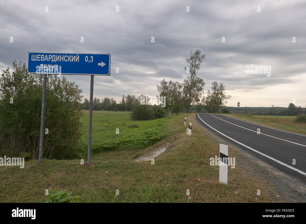 Road sign in russian to Schewardino Redoubt at Borodino battle field in Russia and nearby road Stock Photo