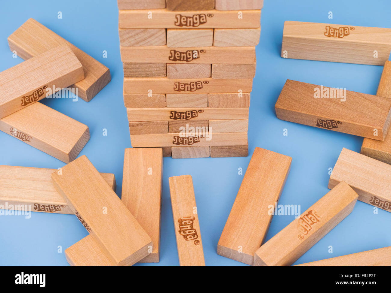 Tambov, Russian Federation - March 03, 2016 Jenga tower constructed and some blocks on blue background. Studio shot. Stock Photo