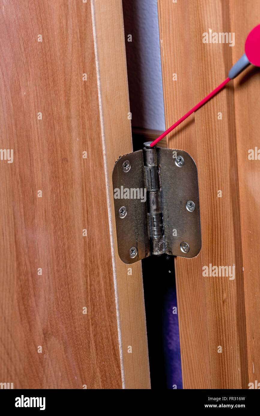 Spray oil is applied to a door hinge Stock Photo Alamy