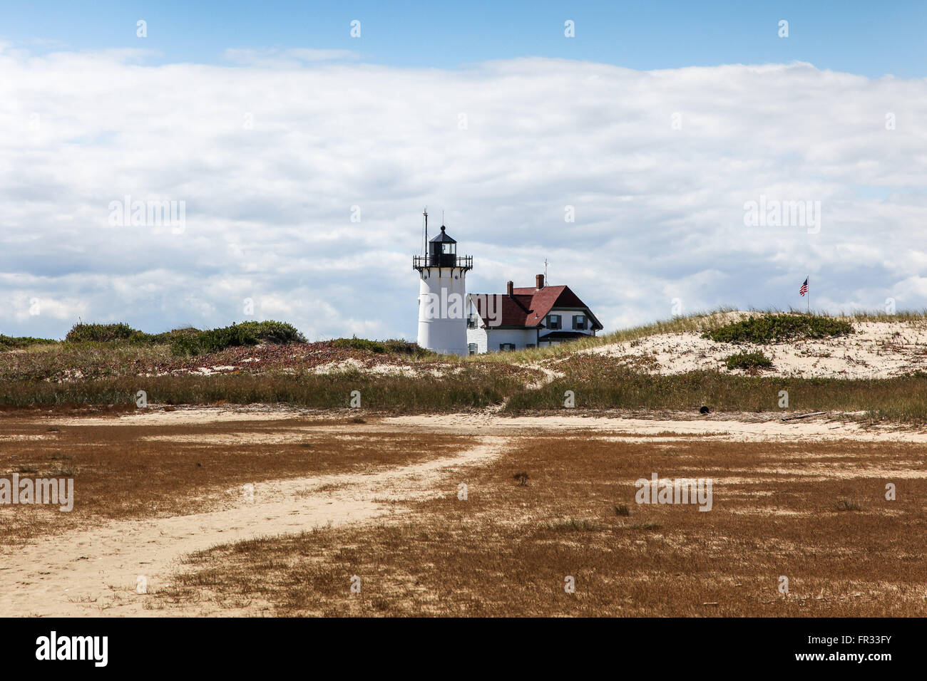 Race point lighthouse with sand dunes and blue sky. Stock Photo