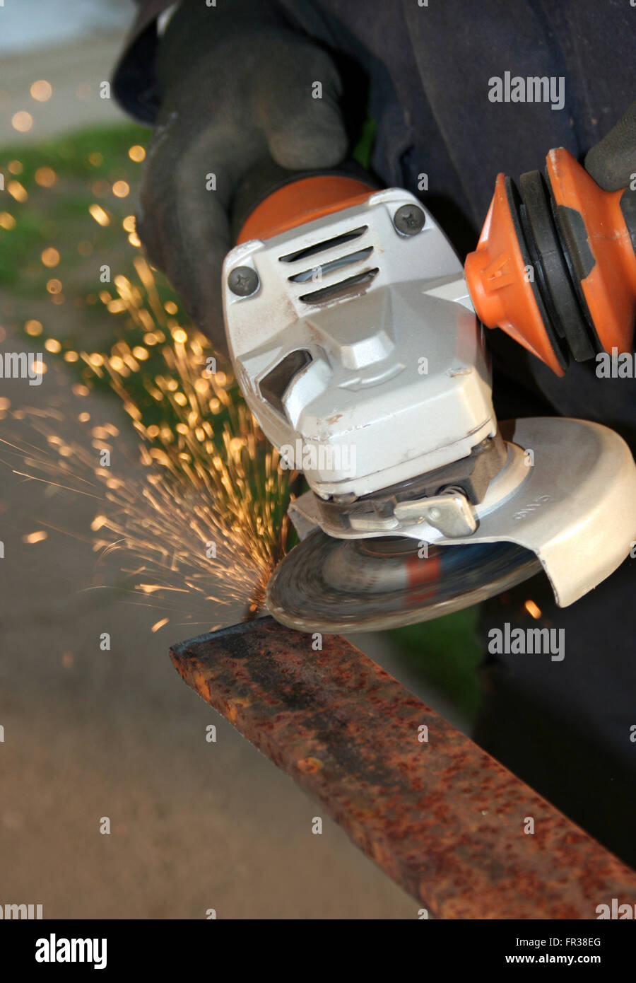 Grinding a metal part wearing standard protection equipment Stock Photo