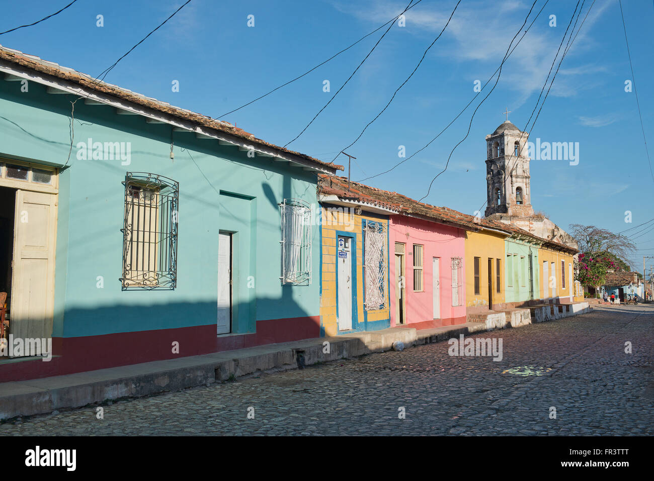 Electricity cables connect colorful houses on a street in the old colonial town of Trinidad, Cuba. Stock Photo