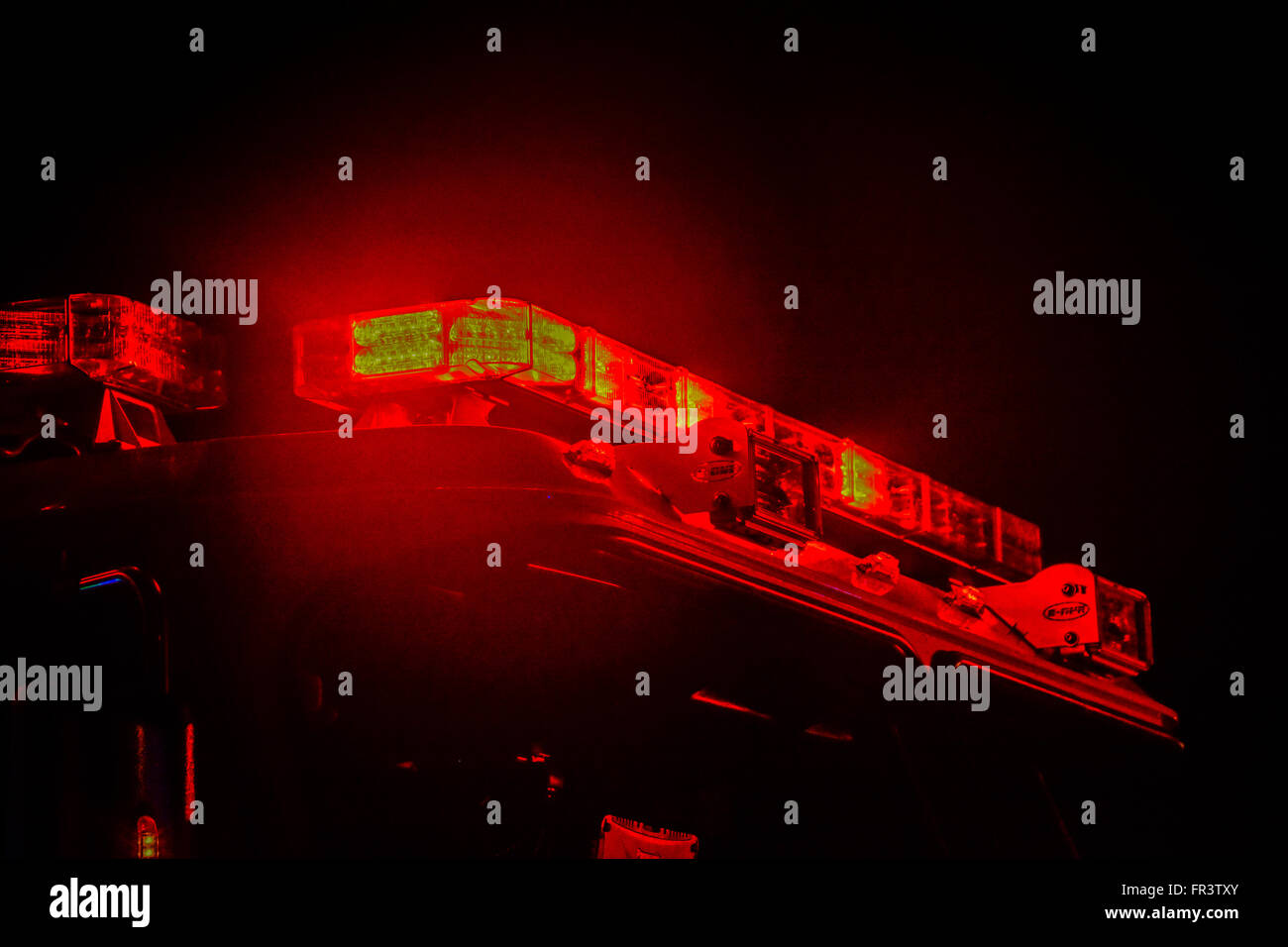 Red flashing police car lights atop a patrol car at night while