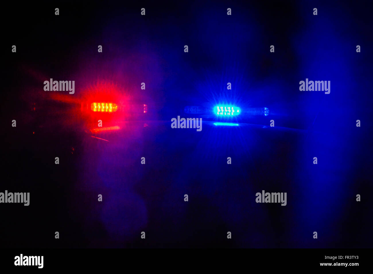 Red and blue flashing police car lights atop a patrol car at night while conducting law enforcement business Stock Photo