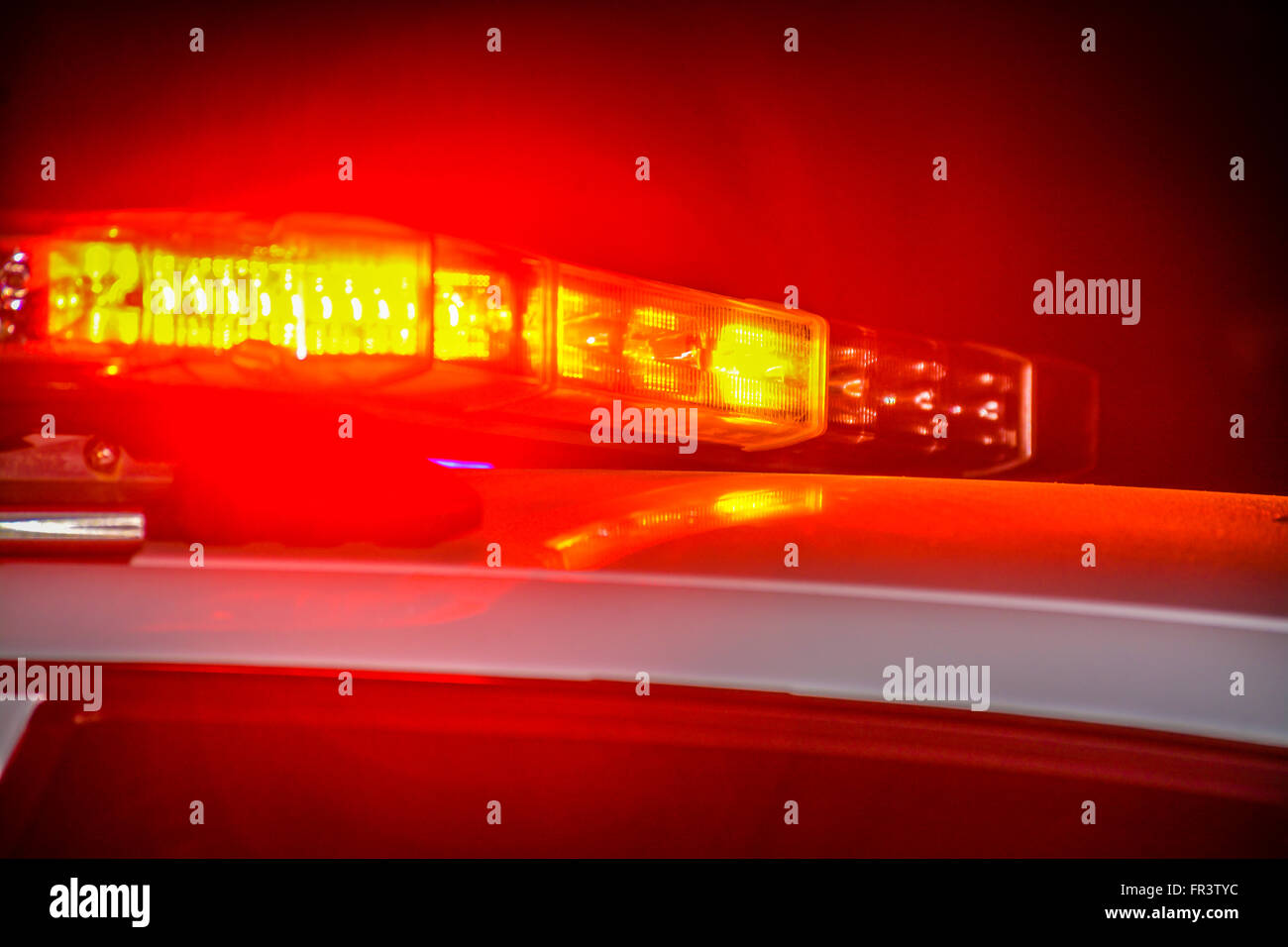 Red and blue flashing police car lights atop a patrol car at night while conducting law enforcement business Stock Photo