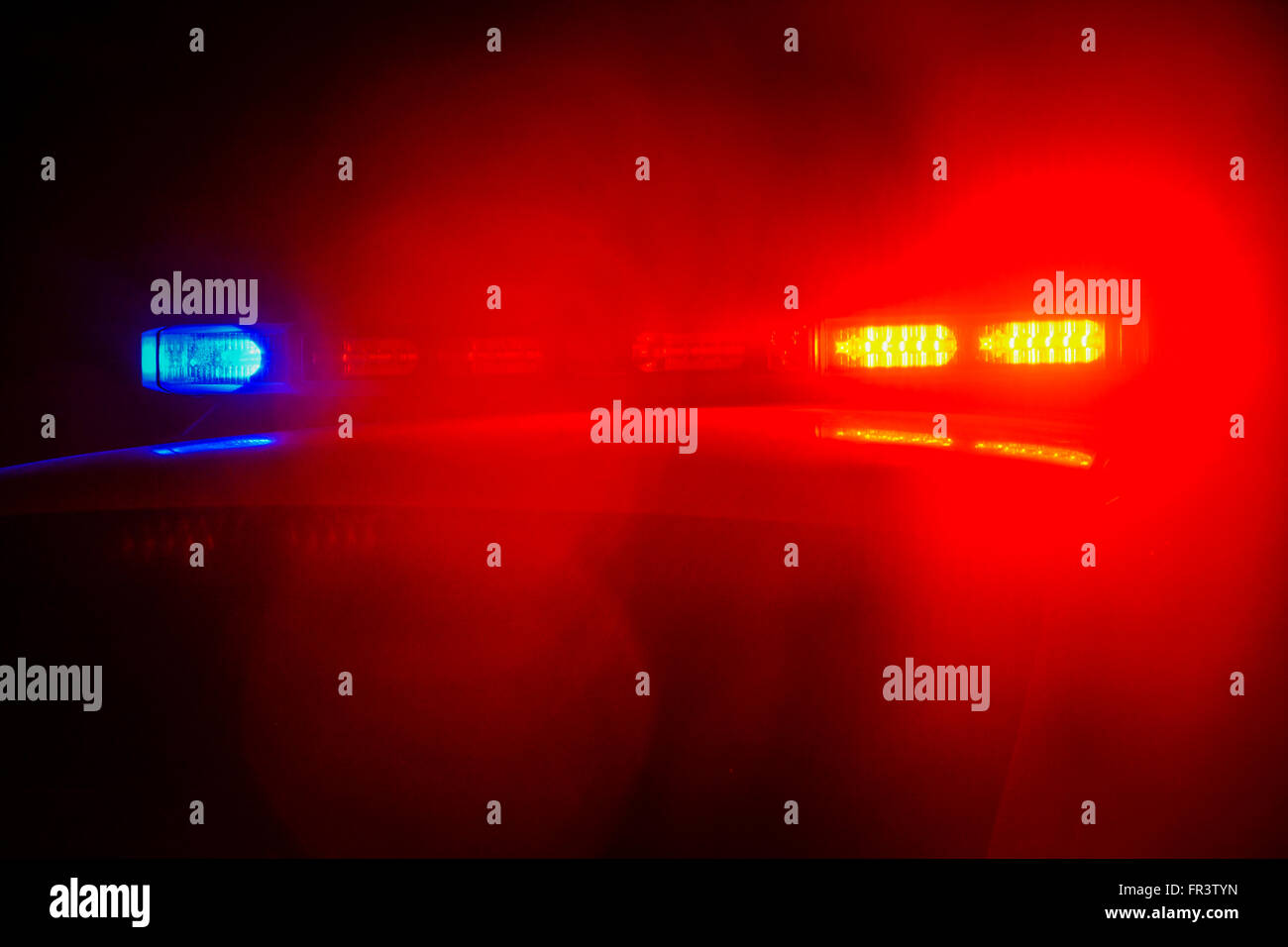 Red and blue flashing police car lights atop a patrol car at night while conducting law enforcement business Stock Photo