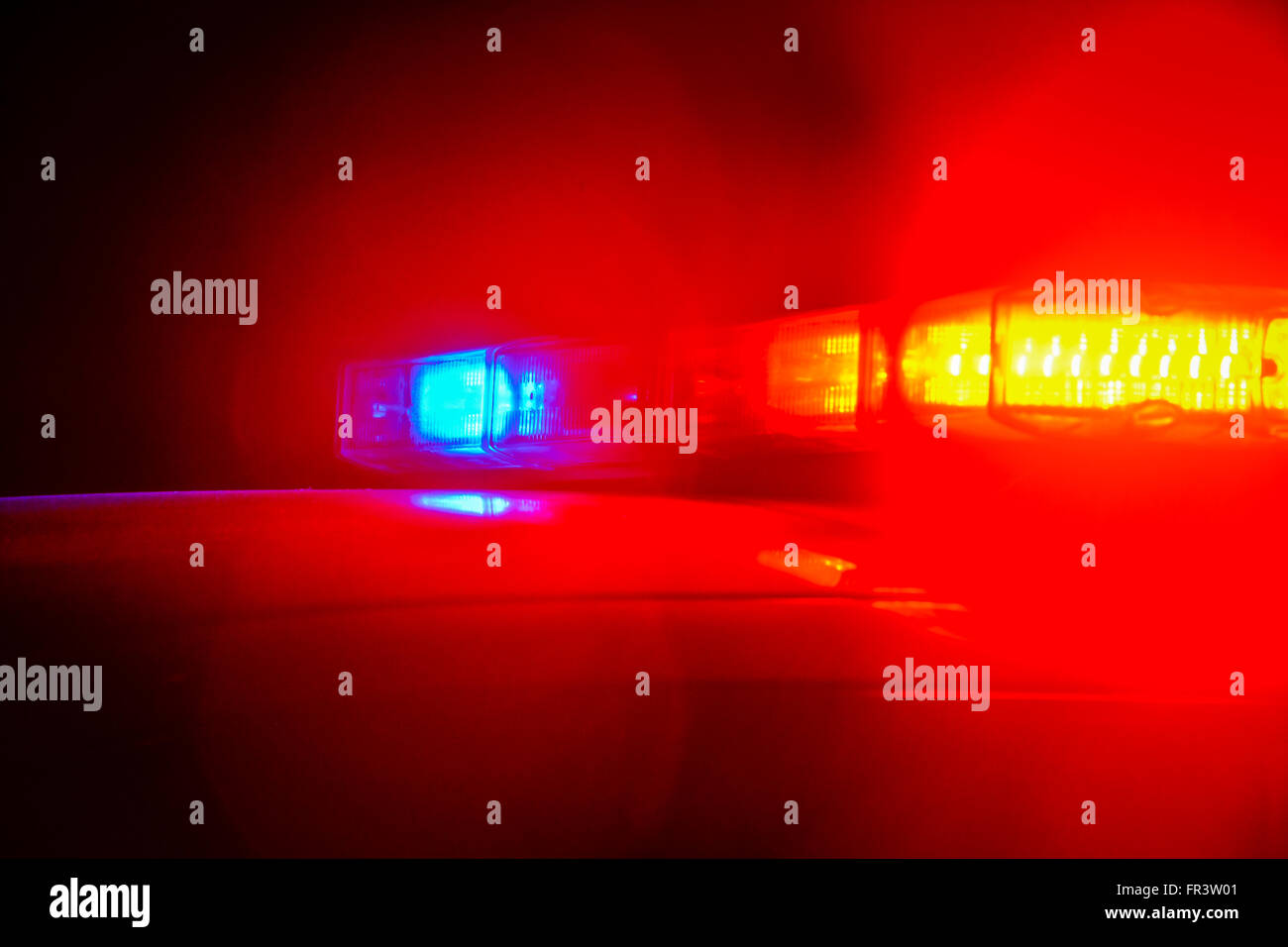 Red and blue flashing police car lights atop a patrol car at night while conducting law enforcement business Stock Photo