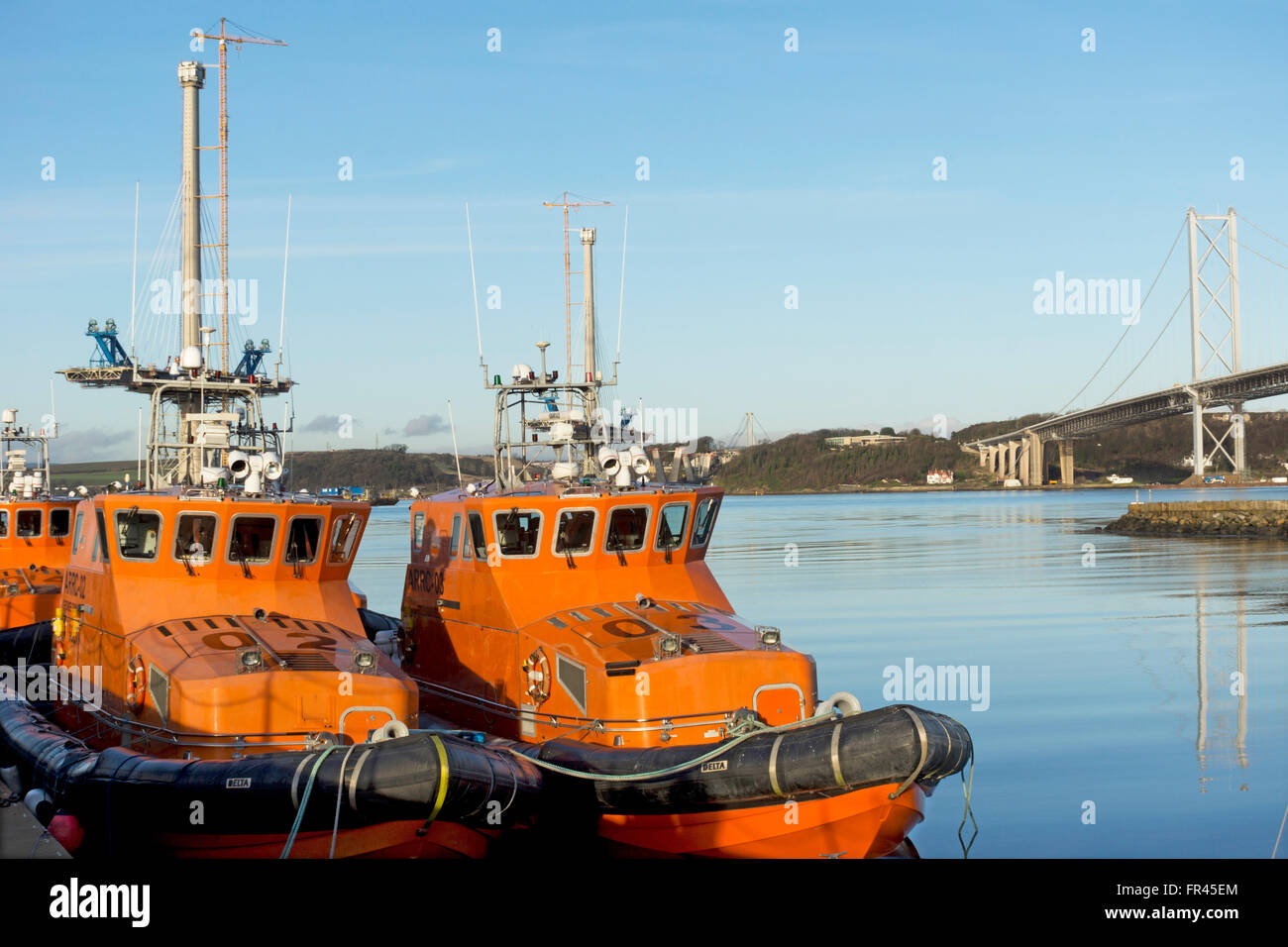 Two boats at Port Edgar on the Firth of Forth near Edinburgh with the Forth Road Bridge  behind Stock Photo