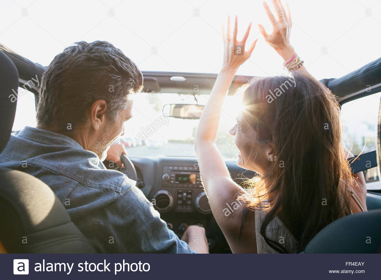 woman with arms in the air in convertible Stock Photo