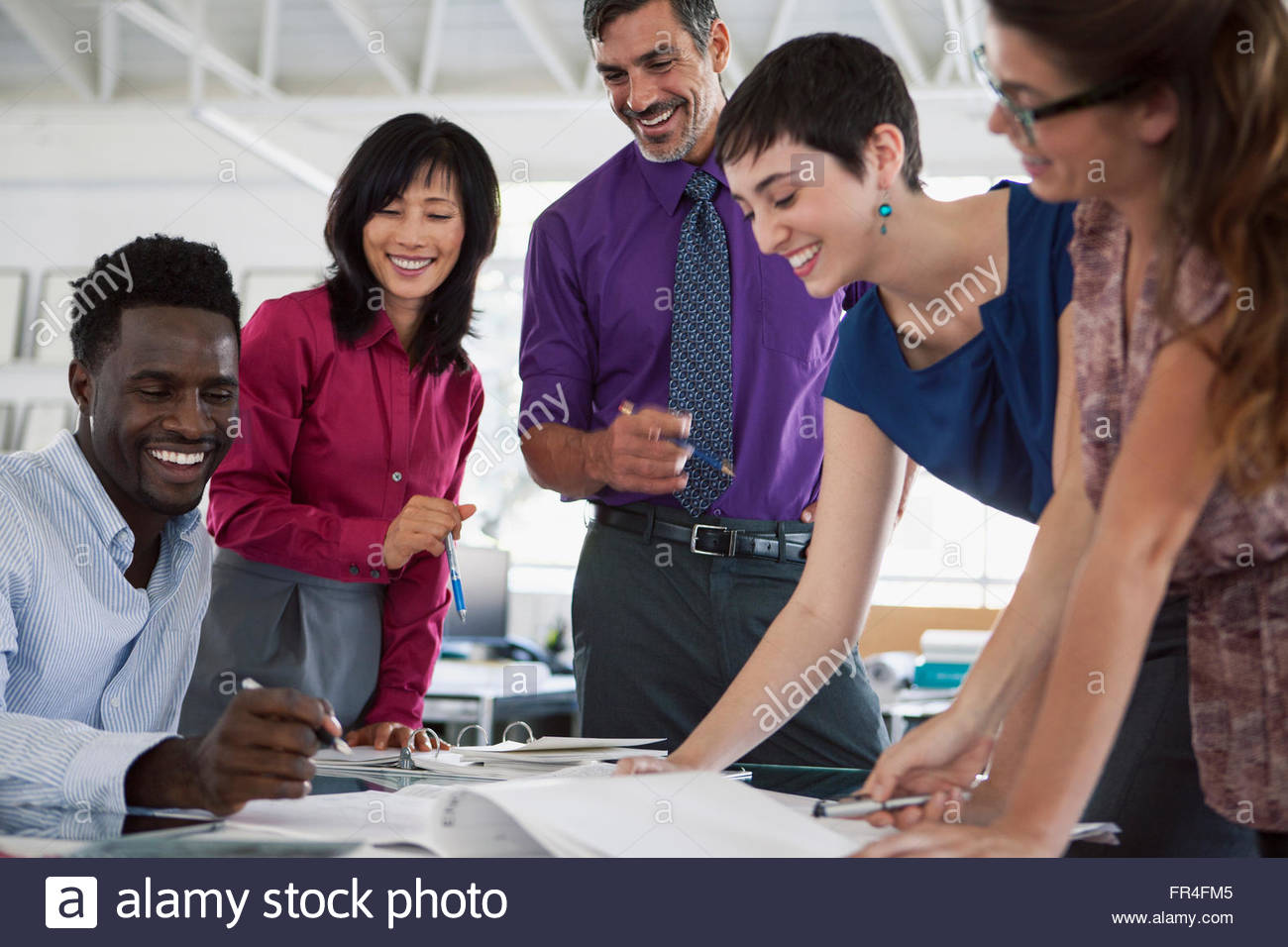 business people having a laugh while reviewing paperwork Stock Photo