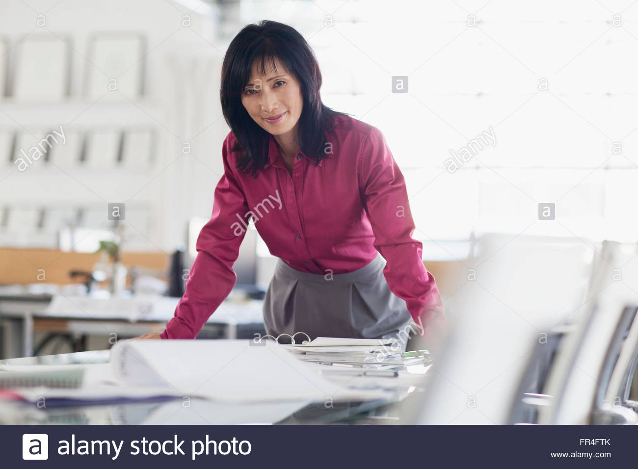 pretty asian businesswoman leaning on desk Stock Photo - Alamy