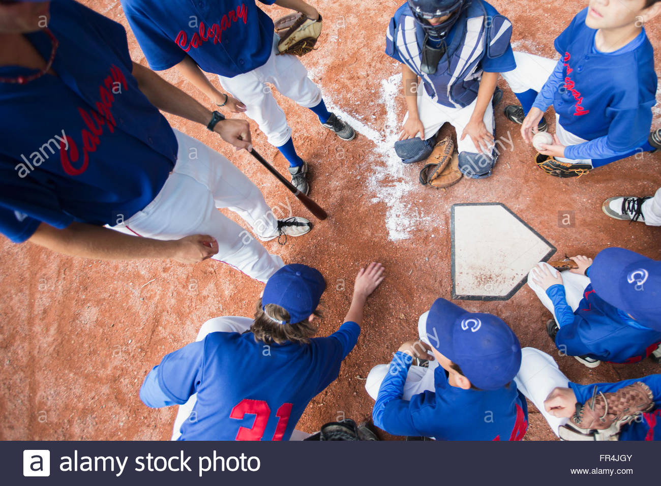 View from above of coach giving pep talk to boys baseball team. Stock Photo