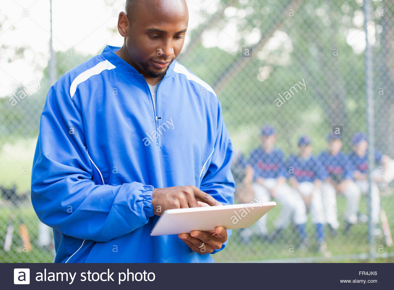 Baseball coach using pc tablet at ball game Stock Photo Alamy