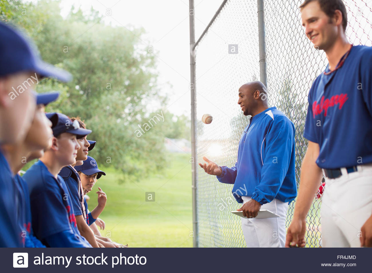 Coaches talking with boys baseball team Stock Photo Alamy
