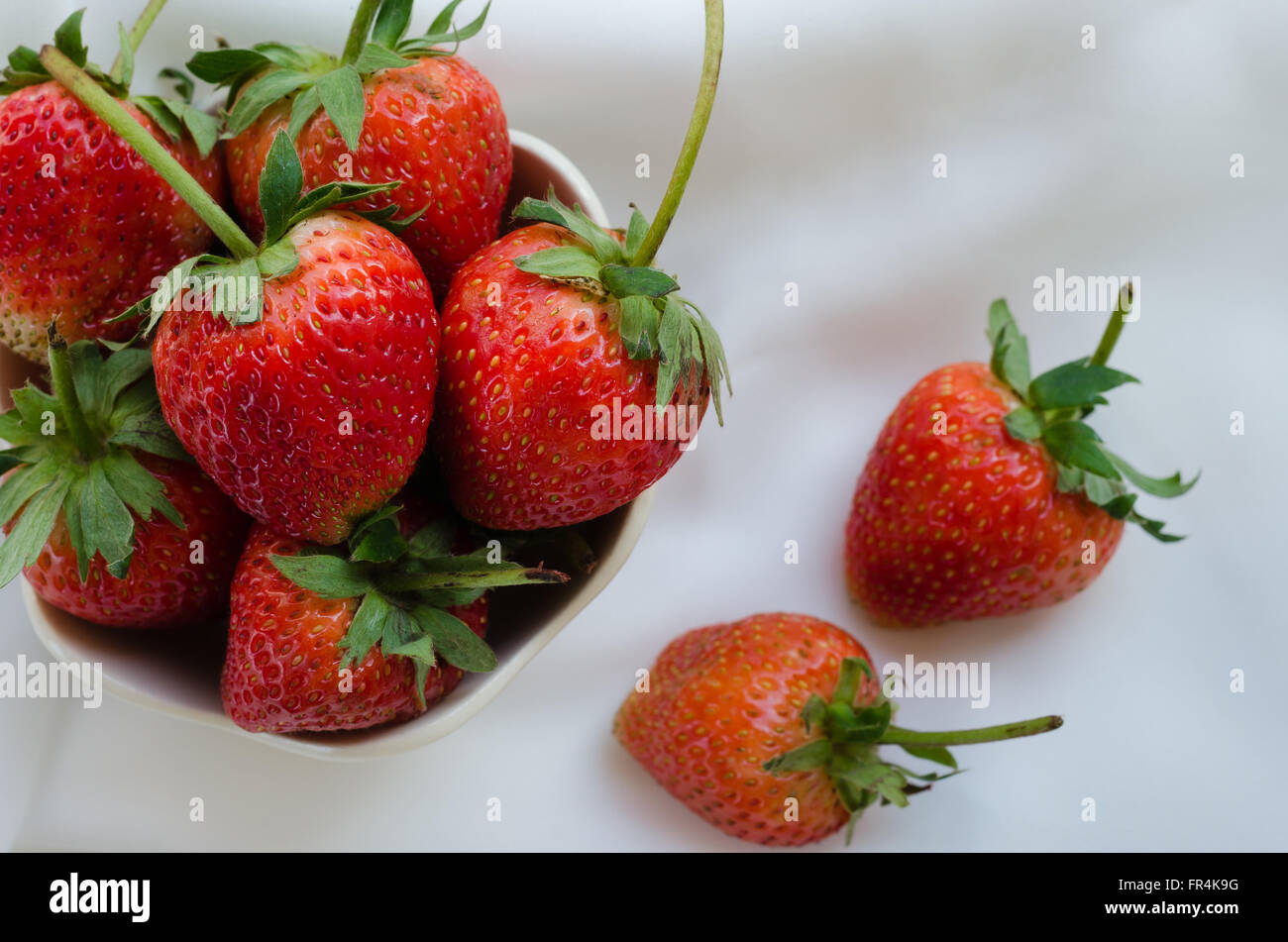 Strawberries In Bowl On White Fabric Background Stock Photo - Alamy