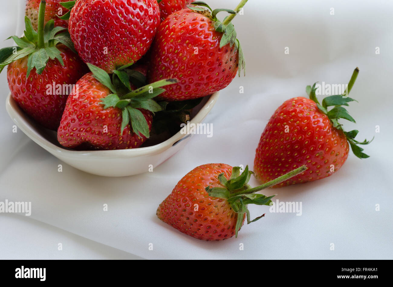 Strawberries In Bowl On White Fabric Background Stock Photo - Alamy