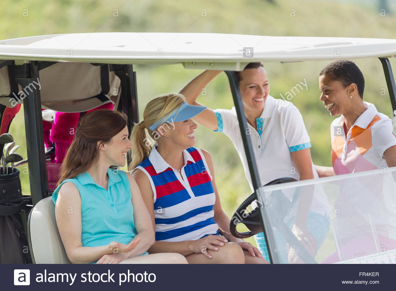 female golfers having a laugh by golf cart Stock Photo