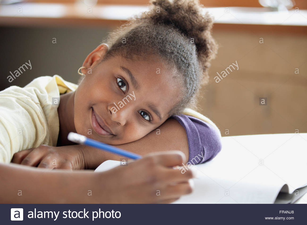 african-american-middle-school-student-leaning-on-school-desk-stock