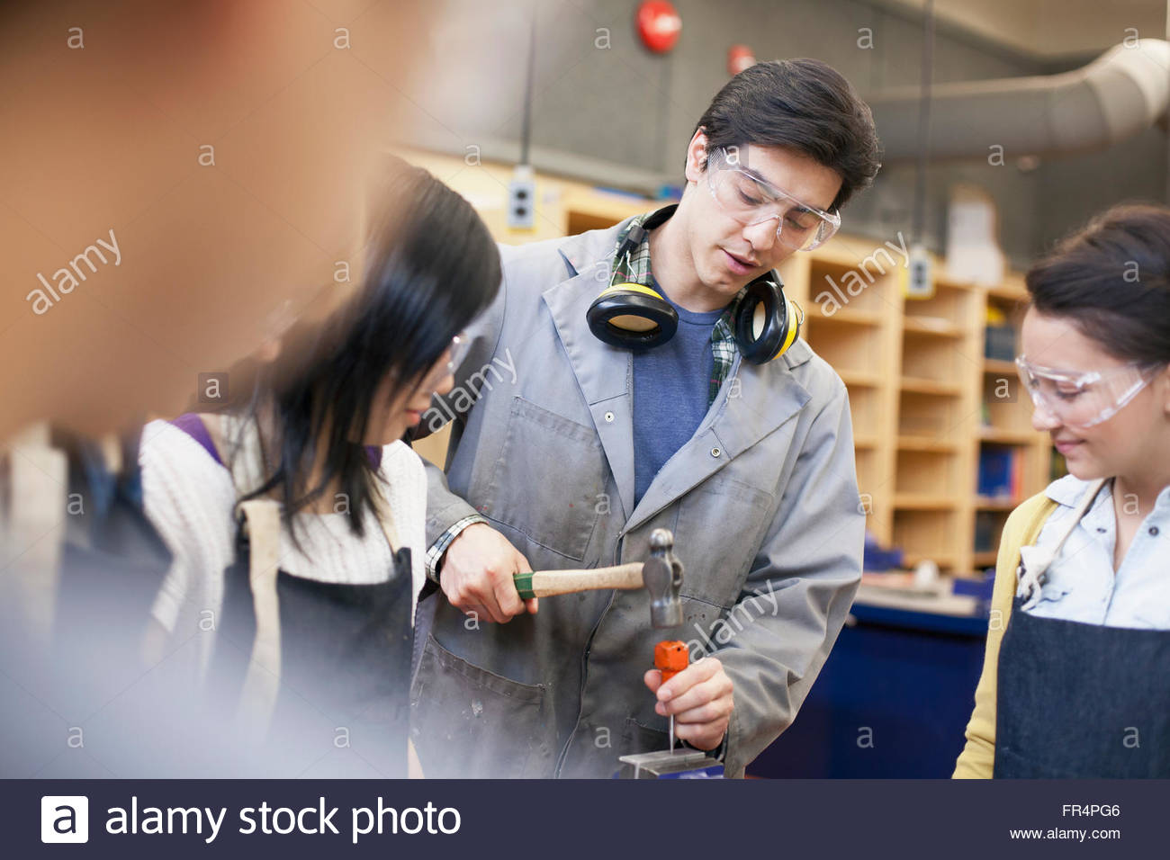 teacher demonstrating in machine shop class Stock Photo Alamy