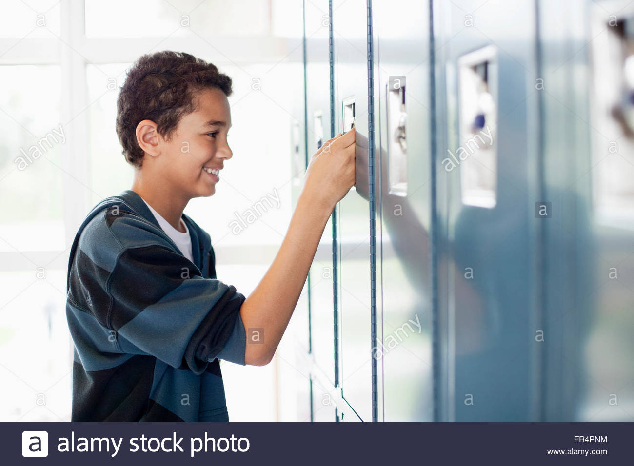 male middle school student opening locker Stock Photo Alamy