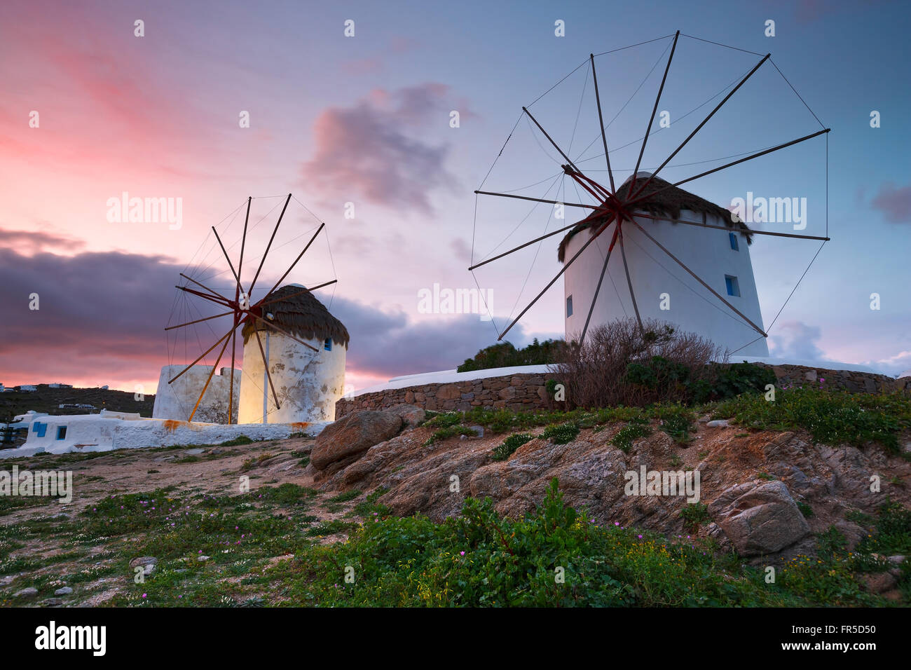 Old traditional windmills over the town of Mykonos. Stock Photo