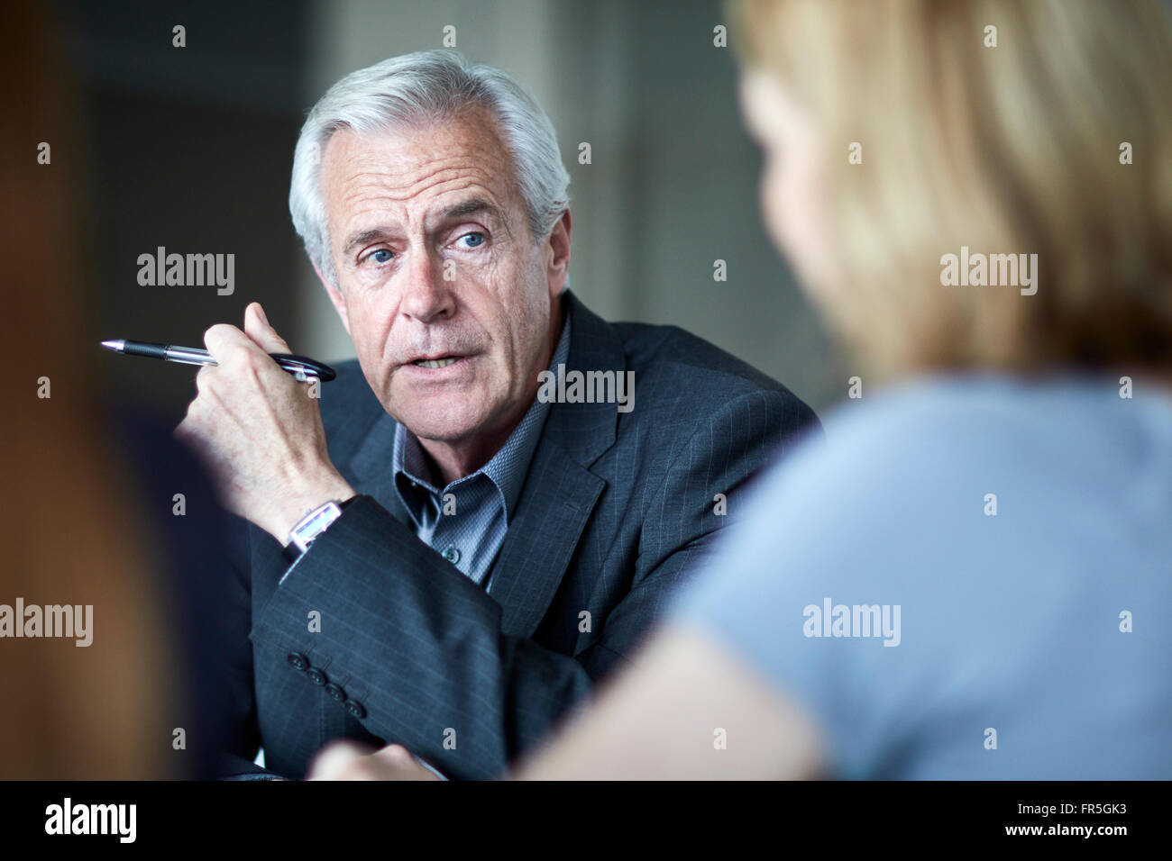 Senior businessman listening to businesswoman in meeting Stock Photo