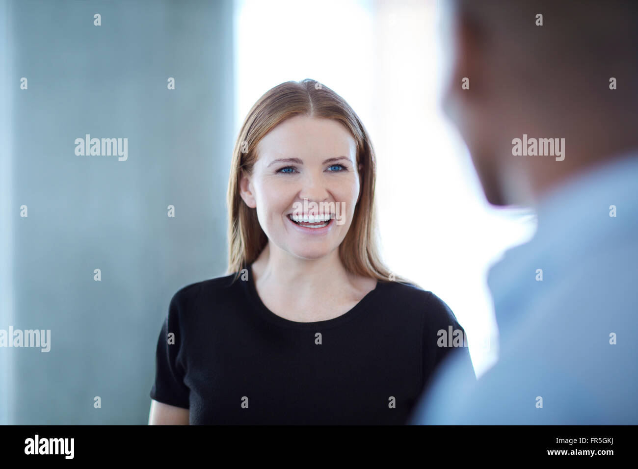 Smiling businesswoman talking to businessman Stock Photo