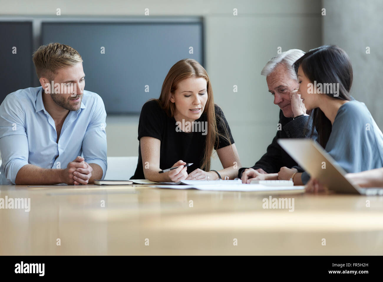 Business people reviewing paperwork in meeting Stock Photo - Alamy