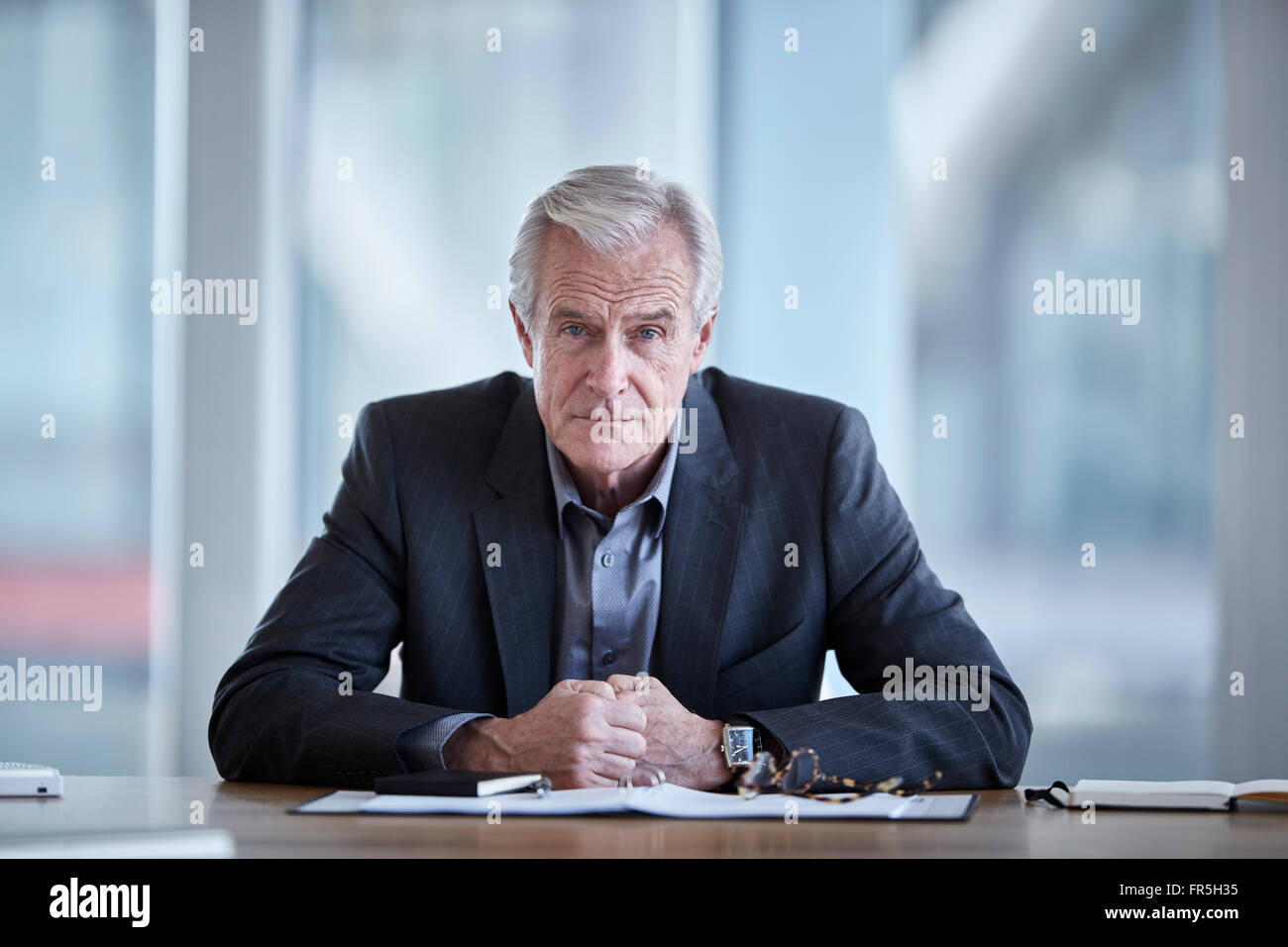 Portrait serious senior businessman in conference room Stock Photo