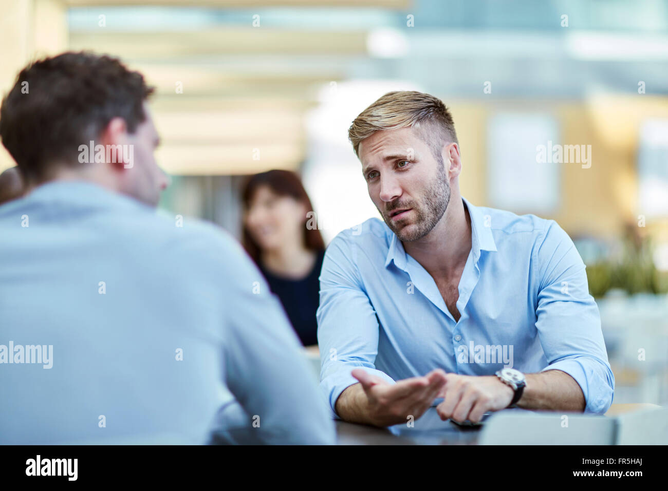 Businessman gesturing and talking to colleague Stock Photo