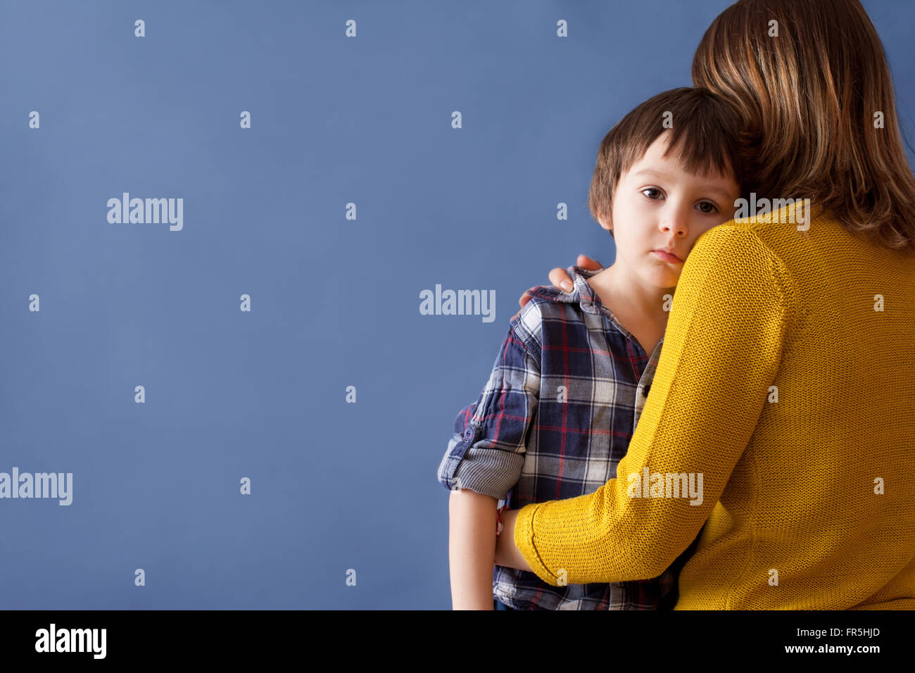 Sad little child, boy, hugging his mother at home, isolated image, copy space. Family concept Stock Photo
